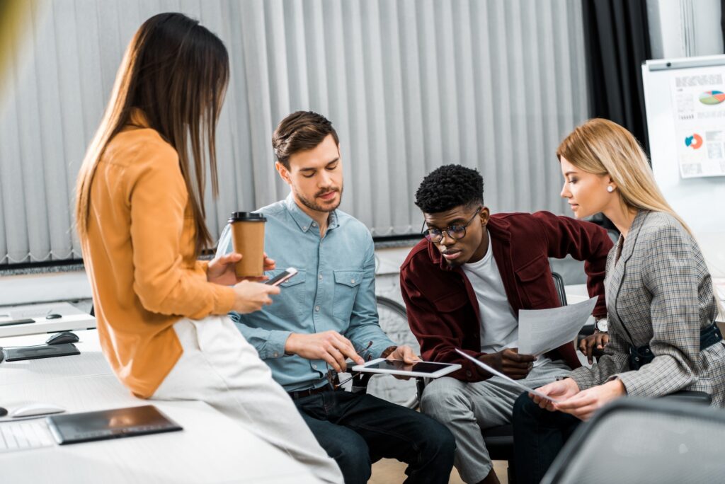 multicultural-young-businesspeople-discussing-new-business-idea-in-office-1024x684 (1)